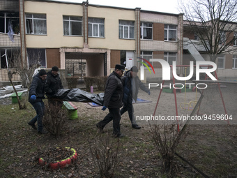 Municipal workers carry bodies of a helicopter crash victims from a kindergarten in the Brovary town, in the outskirts of Kyiv, Ukraine, Jan...