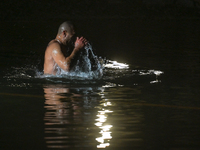 An Orthodox faithful immerses himself three times in the water in honor of the Holy Trinity during the celebration of the  the Orthodox Epip...