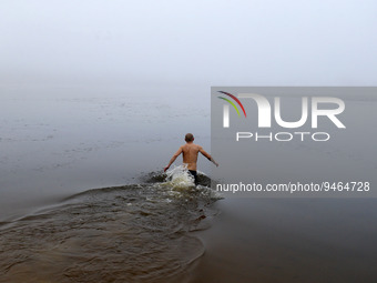 A man takes a dip in icy water during celebration of the Orthodox Epiphany Christian feast in Dnipro River of Kyiv, Uk (