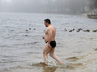 A man takes a dip in icy water during celebration of the Orthodox Epiphany Christian feast in Dnipro River of Kyiv, Uk (