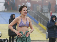 A woman dries herself after a dip in icy water during celebration of the Orthodox Epiphany Christian feast in Dnipro River of Kyiv, Ukraine...