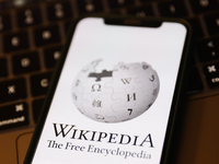 Wikipedia logo displayed on a phone screen and a laptop keyboard are seen in this illustration photo taken in Krakow, Poland on January 19,...