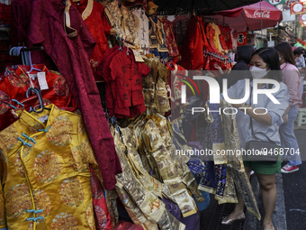 Shoppers look at Chinese traditional dresses which are offered for sale ahead of the Chinese Lunar New Year celebrations in Chinatown, Bangk...