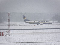 A Boeing 737-800 aircraft of the Irish low cost carrier Ryanair is landing and taxiing during a snow storm in Eindhoven Airport in the Nethe...
