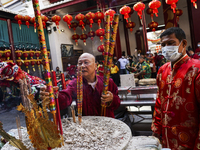 Thai and Chinese people pray with incense and joss sticks for good at a Chinese temple during celebrations for the Lunar New Year in Bangkok...