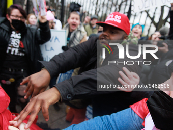 An anti-abortion rights demonstrator, red hat in center, assaults an abortion rights supporter outside of the White House during the Women's...