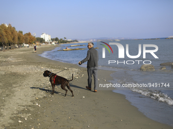 A man walks his dog along the beach in the Mediterranean port of Limassol. Cyprus, Tuesday, January 24, 2023. (