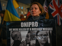 A protester holding a poster with words 'Dnipro, we were killed by a russian missile' is seen during the 'Protest in Support of Ukraine' on...