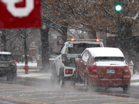 A car is towed by a tow truck amid heavy snow fall at Norman, Oklahoma, USA. 24 January 2023 (