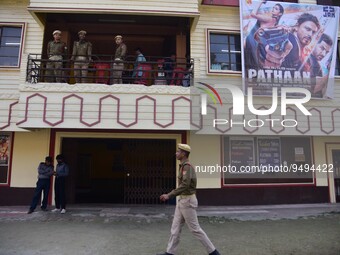 Police personnel guard outside a cinema hall during the first show of the  Bollywood movie 'Pathaan' in Nagaon District of Assam , India on...
