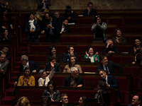 Opposition MPs applaud a speech critical of the government during the government question session, in Paris, Tuesday 24 January, 2023. (