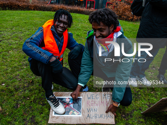 Two Sudanese refugees are beating a placard with the face of Van Al Burhan, during a protest against the 'Framework Agreement' in The Hague,...