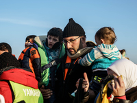 Refugees and migrants aboard a dinghy approach the northeastern Greek island of Lesbos after traveling from the Turkish coast  Dec. 8, 2015....
