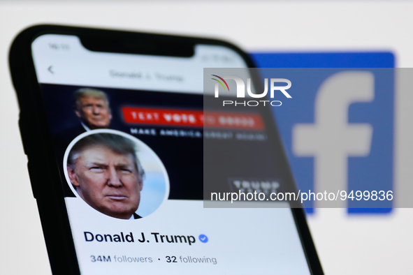 Donald Trump account on Facebook displayed on a phone screen and Facebook logo displayed on a screen in the background are seen in this illu...