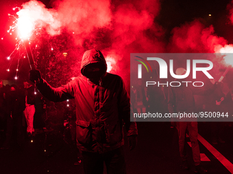 Demonstrators hold flares during a torchlight procession in the streets of Paris on 26 January 2023 to protest against the French government...