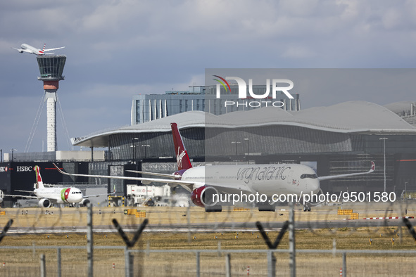 Virgin Atlantic Airways Airbus A350-1000 aircraft as seen taxiing infront of other planes, the air traffic control tower, the gates of the t...