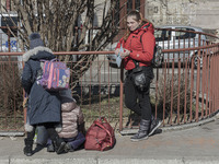 A devasted mother just arrived in Poland as seen talking on the phone and crying next to her children. War refugees from Ukraine arrive at P...