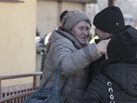 Ukrainian old lady arrives in Poland and hugs her relatives while crying. War refugees from Ukraine arrive at Przemysl railway station and g...