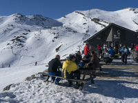 Skiers rest on the terrace of one of the cafeterias in the ski and mountain resort of Alto Campoo or Branavieja which is located in the muni...