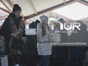 People who just arrived at the station eat warm soup. War refugees from Ukraine arrive at Przemysl railway station and get warm food. Civili...