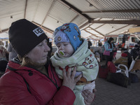 A mother who just arrived in Poland is holding her baby in a blanket. War refugees from Ukraine arrive at Przemysl railway station and get w...