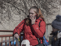 A devasted mother just arrived in Poland as seen talking on the phone and crying next to her children. War refugees from Ukraine arrive at P...