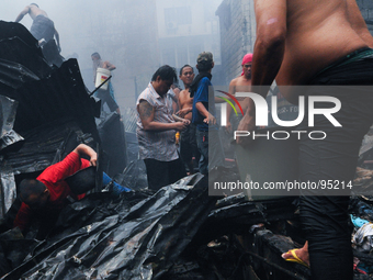 MANILA, Philippines - Residents go hand in hand in helping the firefighters put out the fire completely in a shanty community in Malate, Man...