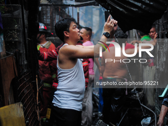 MANILA, Philippines - A resident takes photos of the houses burnt in a shanty community in Malate, Manila on 29 April 2014. At least three p...