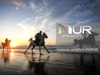 Palestinian men ride on their horses during sunset on Gaza beach, on February 3, 2023.
 (