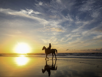 A Palestinian man rides his horse in front of Gaza beach during sunset, on February 3, 2023. (