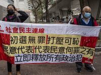 Pro-democracy protesters holding up a banner outside the West Kowloon Magistrates Court before the trail begins on the 47 Pro-Democracy Figu...