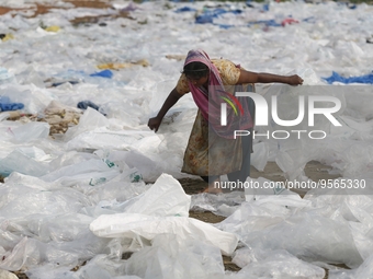 A woman works as she dries polythene plastic bags in Dhaka, Bangladesh on February 9, 2023. (