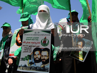 RAMALLAH, PALESTINE -April 30, 2014: Palestinian  girls hold poster for two Hamas members Adil and Imad Awadallah, who was reportedly killed...