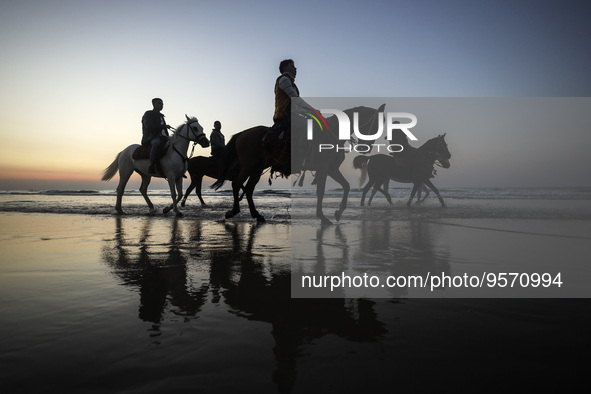 Palestinians men ride on their horses during sunset on Gaza beach, on February 10, 2023. 