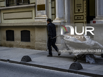 

A paper collector is walking on the sidewalk in front of the Central Bank of the Republic of Turkey. Istanbul, Turkey, on February 17, 202...