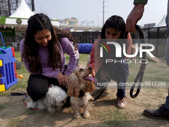 Women play with their pet dogs during a show organized at one of the biggest pet-gathering events in Noida, on the outskirts of New Delhi, I...
