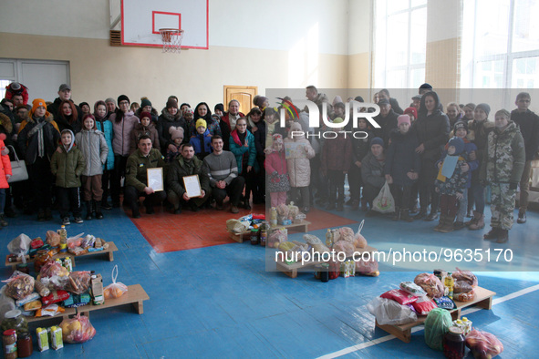 KHERSON, UKRAINE - FEBRUARY 21, 2023 - Residents of the Shumenskyi district and members of the Volunteers of Prydessennya association pose f...