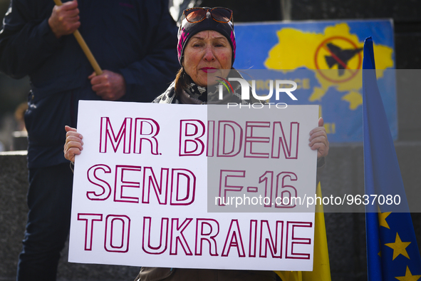 A woman holds a banner 'Mr Biden Send F-16 To Ukraine' during a daily demonstration of solidarity with Ukraine at the Main Square one day ah...