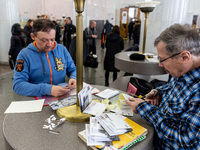 Members of the public write postcards with the new FCK PTN stamps which has its premiere on the anniversary of Russian invasion and uses the...