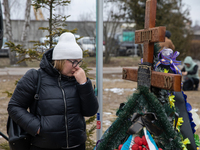 Woman crying watching on the tomb of Oleksandr Shvets ukrainian military killed during the war in Ukraine, February 24, 2023. One year from...