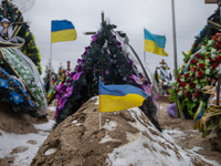 Small flag of Ukraine weaving on the tomb of ukrainian military an the Alley of Glory, Bucha, Kyiv region. February 24, 2023. One year from...