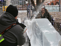 Man uses a chainsaw to carve an ice sculpture of a centaur out of blocks of solid ice during Icefest in Toronto, Ontario, Canada on February...