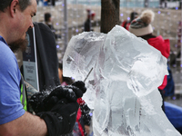 Man uses a file to carve an ice sculpture of a centaur out of blocks of solid ice during Icefest in Toronto, Ontario, Canada on February 19,...