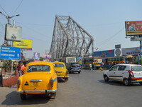 

Yellow taxis are seen in front of Howrah Bridge in Kolkata, India, on March 5th, 2023. The government is planning to phase out yellow taxi...