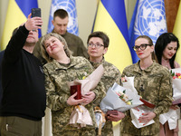 Ukrainian female soldiers pose for a photo with flowers and state awards awarded by Ukrainian President to Ukrainian women from the army, re...