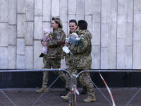 Ukrainian female soldiers walk with flowers and state awards awarded by Ukrainian President to Ukrainian women from the army, rescuers, and...
