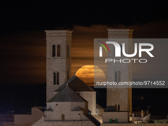 The full moon rises behind the towers of the Duomo in Molfetta, Italy on March 8, 2023. March's full moon is also known as the worm moon, be...