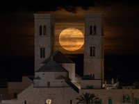 The full moon rises behind the towers of the Duomo in Molfetta, Italy on March 8, 2023. March's full moon is also known as the worm moon, be...