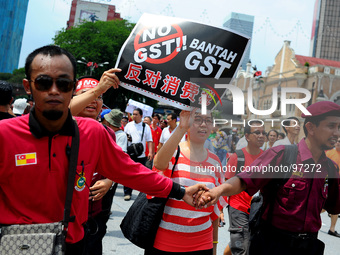 Protestors hold up placards during a protest against the implementation of the Goods and Services Tax (GST)  in Kuala Lumpur, Malaysia, Thur...