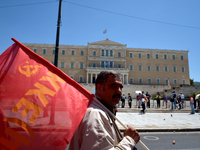 A communist protester holds the flag of the Greek Communist Party in front of the Greek Parliament in central Athens, on May 1, 2014. (